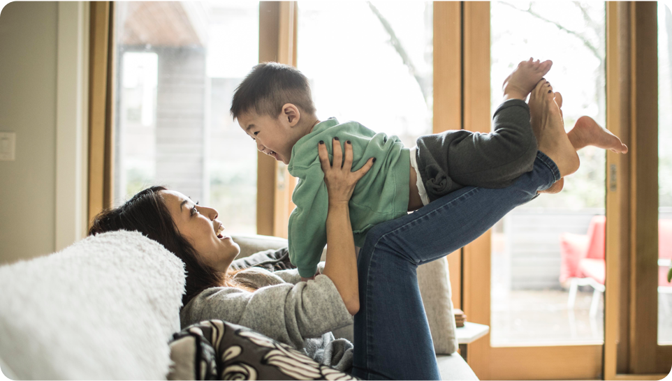 A mother holding her young child in the air
